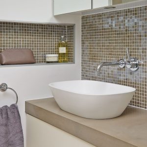 Baie mica cu nise depozitare in perete, culori neutre, lavoar pe blat